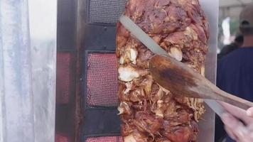 seletivo foco para vídeo do uma pessoas mão corte carne em uma doador Kebab em rotativo vertical cuspir video