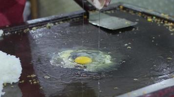 seletivo foco em a omelete este é ser frito e vendido às a culinária festival às noite. com movimento borrão efeito video