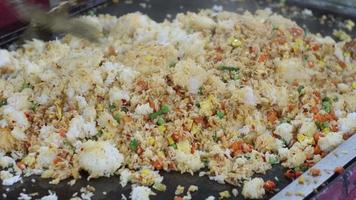 selective focus on videos of rice being stirred to make fried rice which is sold at culinary festivals at night. with motion blurr effect