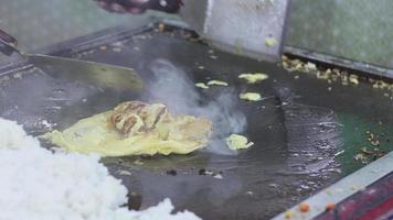 selettivo messa a fuoco su il frittata quello è essere fritte e venduto a il culinario Festival a notte. con movimento sfocatura effetto video