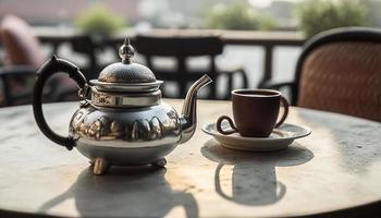 A cup of tea and tea kettle on the table on a rooftop photo