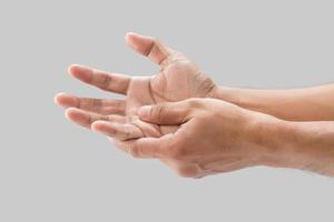 A man grab hand palm because the hand palm was injured. Hand pain. On a gray background. photo