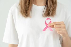 Woman hold pink ribbon breast cancer awareness. Female health check consciousness. international Women Day and World Cancer Day. sign cancer, Symbolic, health care, support patients, timely diagnosis photo