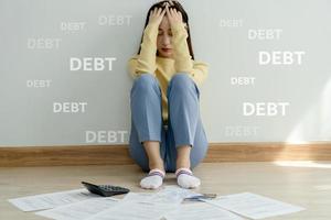 Stressed and headache asian woman with large bills or invoices no money to pay to expenses and credit card debt. shortage, Financial problems, mortgage, loan, bankruptcy, bankrupt, poor, empty wallet photo