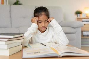 asiático joven pequeño niña aprender a hogar. hacer deberes con tipo madre ayuda, animar para examen. Asia niña contento educación en el hogar mamá asesorar educación juntos. foto