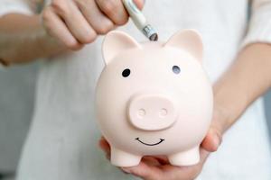 Save money. business woman putting coin into piggy bank for saving. wealth, Finance, business, investment, retirement, future, accounting, plan life, economize, banking, family, health. photo