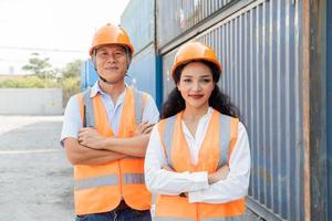 Female Asian engineer and foreman engineer loading containers from cargo ship for export. There is a container in the background. photo