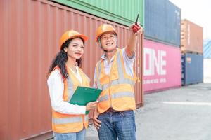 Female Asian engineer and foreman engineer loading containers from cargo ship for export. There is a container in the background. photo