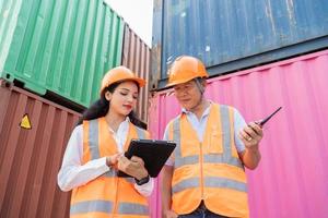 Female Asian engineer and foreman engineer loading containers from cargo ship for export. There is a container in the background. photo
