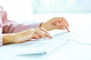 Woman office worker typing on the keyboard photo