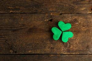 Green shamrock clovers on wooden background photo