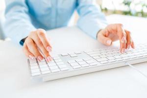 Woman office worker typing on the keyboard photo