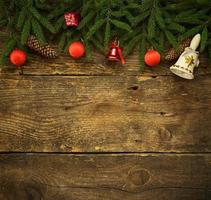 Christmas tree branches with cones and christmas decorations on wooden texture ready for your design photo