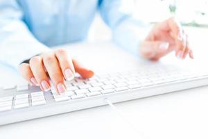 Woman office worker typing on the keyboard photo