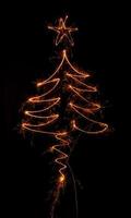 árbol de navidad hecho por bengala sobre un negro foto
