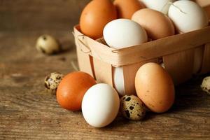 Chicken and quail eggs on a wooden rustic background photo