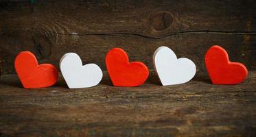 Red and white hearts on old shabby wooden background photo