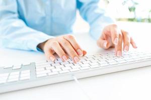 Woman office worker typing on the keyboard photo