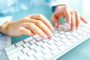 Woman office worker typing on the keyboard photo