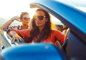 Two young girls driving a cabriolet photo