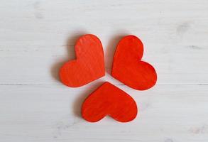 Red hearts on white wooden background photo