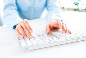 Woman office worker typing on the keyboard photo