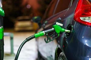 coche repostaje en un gasolina estación en invierno a noche foto