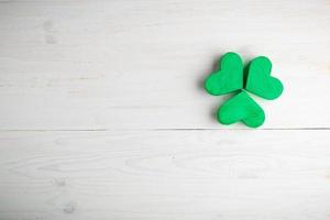 Green shamrock clovers on white wooden background photo