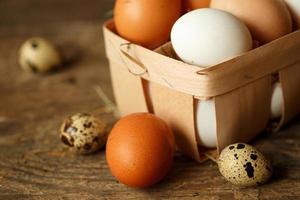 Chicken and quail eggs on a wooden rustic background photo