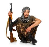 árabe nacionalidad en camuflaje traje y toca árabe con automático pistola en blanco antecedentes foto