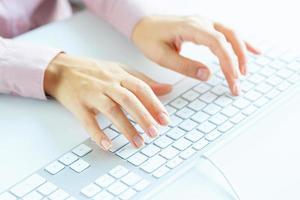 Woman office worker typing on the keyboard photo