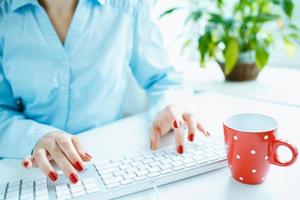 Woman office worker typing on the keyboard photo