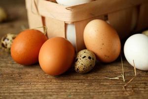 Chicken and quail eggs on a wooden rustic background photo