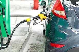 coche repostaje en un gasolina estación en invierno foto