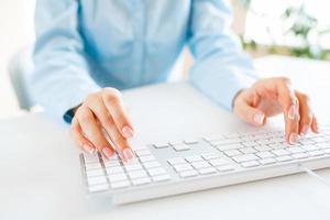Woman office worker typing on the keyboard photo