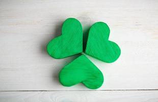 Green shamrock clovers on white wooden background photo