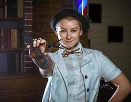 Fashion woman barber hairstylist with scissors in hand in the barbershop photo