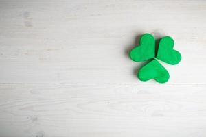 Green shamrock clovers on white wooden background photo
