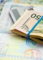 americano dinero y crédito tarjetas mentira en el parte superior de el abrió pasaporte foto