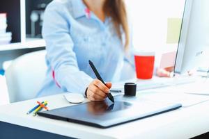 Graphic designer drawing something on graphic tablet at the home office photo