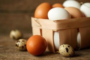 Chicken and quail eggs on a wooden rustic background photo