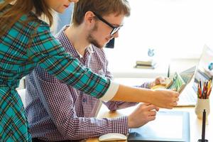 Young colleague looking to a color paint palette at home office photo