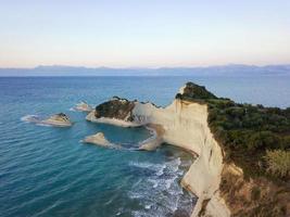 Aerial photo of Cape Drastis at Corfu island in Greece at sunset. Picturesque coast of Corfu island