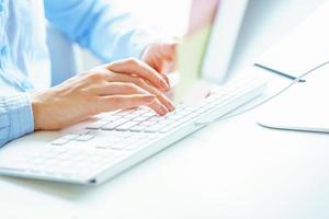 Woman office worker typing on the keyboard photo