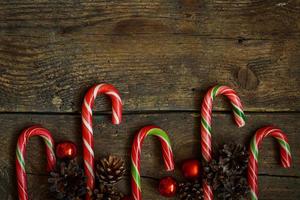 Christmas border with cones, christmas decorations and candy cane on  wooden boards photo