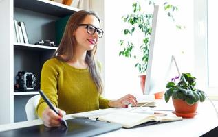 Artist drawing something on graphic tablet at the home office photo