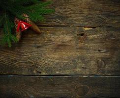 Christmas tree branches with cones and christmas decorations on wooden texture ready for your design photo