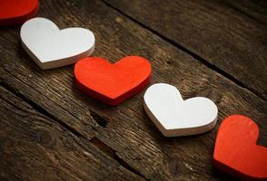 Red and white hearts on old wooden background photo