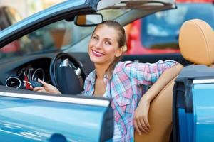 Young pretty woman sitting in a convertible car with the keys in hand photo