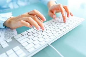 Woman office worker typing on the keyboard photo